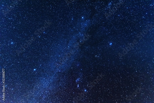 A bright starry night in the mountains with the Milky Way in the sky, Venus and millions of stars highlighting beautiful mountain huts in the valley.