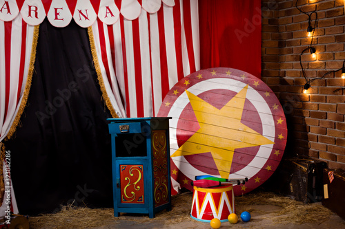 Circus backstage in retro style, drum on aa pedestal. Red stripped curtain background with various circus objects. Circus Theater stage. Old circus arena interior photo