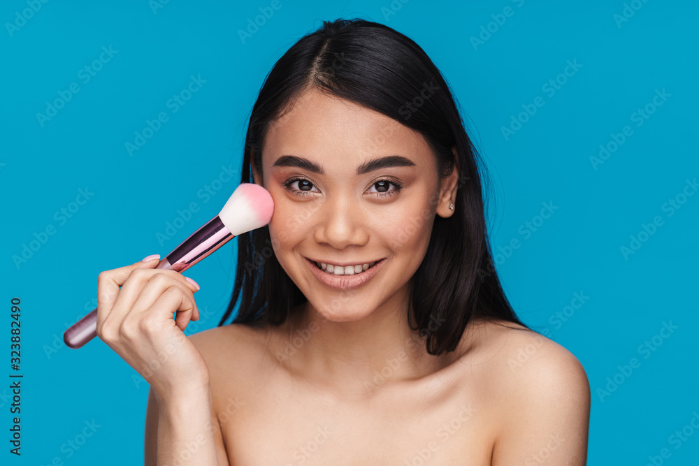 Positive young woman apply powder with brush. Positive young woman apply powder with brush.