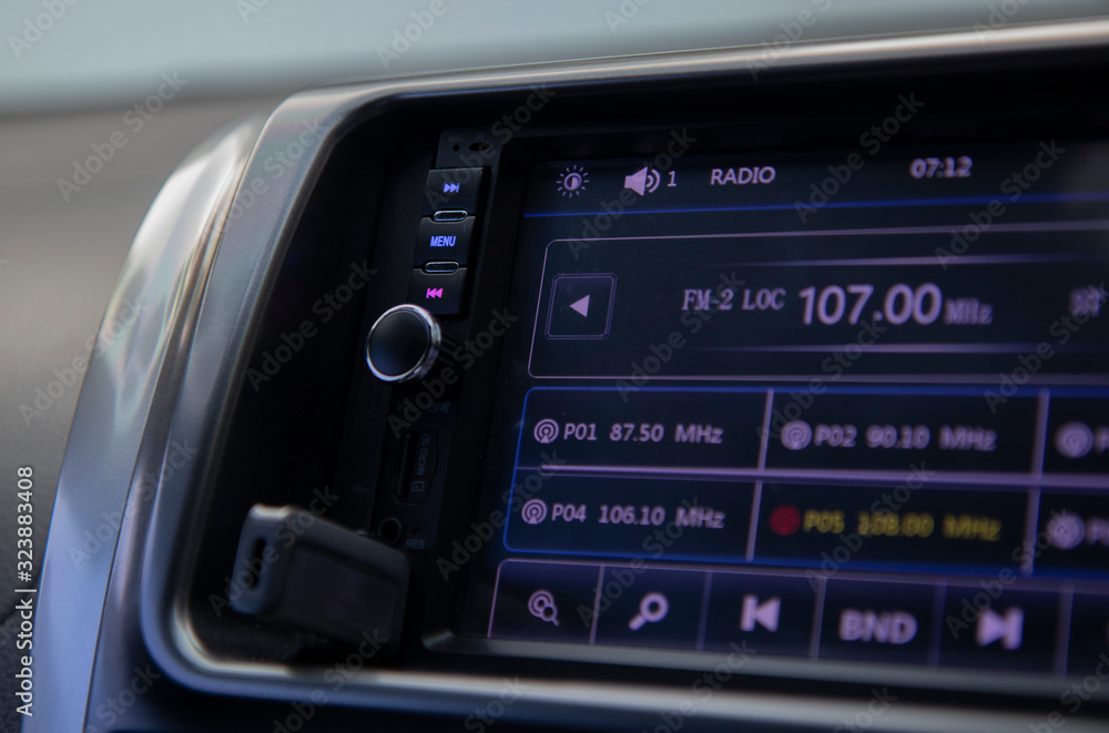 Close up, red forward button and blue menu button On the side of the screen, the audio system is showing radio waves. There is flash drive plugged in on the bottom of screen for playing music. Close up, red forward button and blue menu button On the side of the screen, the audio system is showing radio waves. There is flash drive plugged in on the bottom of screen for playing music.