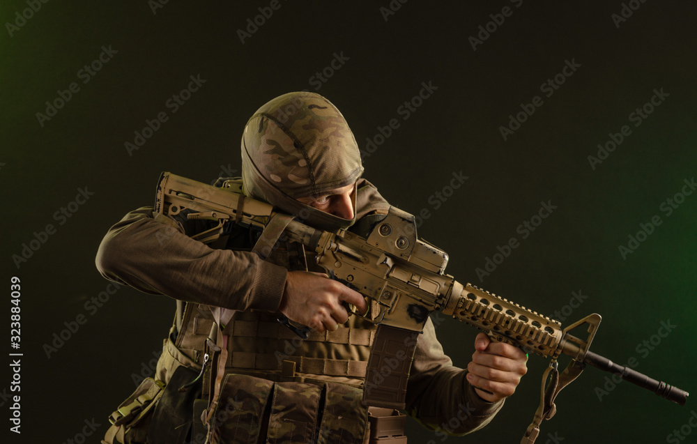 soldier-saboteur in military clothing with weapons on a dark background