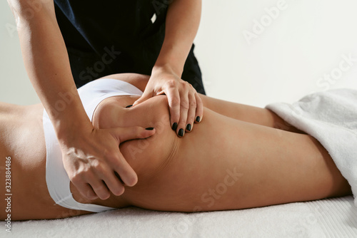 Fat burning massage. masseur making anti cellulite massage for young woman in wellness center or beauty salon. Perfect skin beauty concept