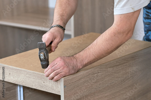 The master collects the wooden furniture with the old hammer