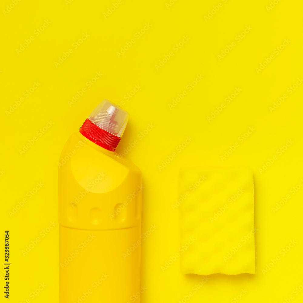 House cleaning concept. Household chemicals, disinfectant, bleach, antibacterial gel, yellow rubber gloves, sponge, rags on yellow background. Flat lay top view copy space. Cleaning accessories