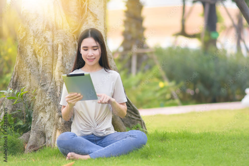 Fototapeta premium Woman use tablet sitting at city park happiness in day time online internet technology