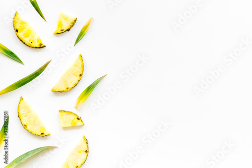 Pineapple slices on white background top-down frame copy space