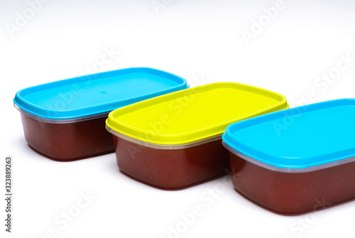 3 tupperwares of preserved quince in a white background photo