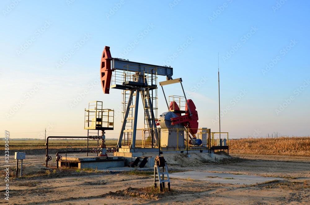 Oil drilling derricks at desert oilfield for fossil fuels output and crude oil production from the ground. Oil drill rig and pump jack. Oil drilling derricks at desert oilfield for fossil fuels output and crude oil production from the ground. Oil drill rig and pump jack.