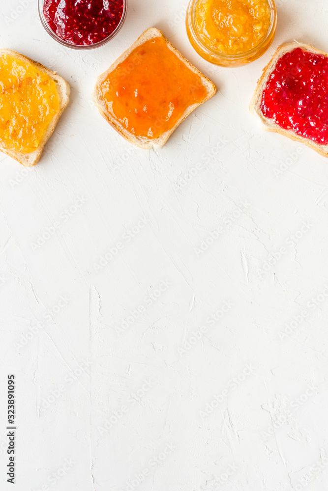 Toast with colorful fruit jam frame on white background frame copy space Toast with colorful fruit jam frame on white background frame copy space