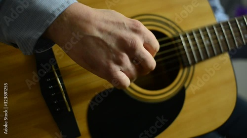 male hands playing acoustic guitar