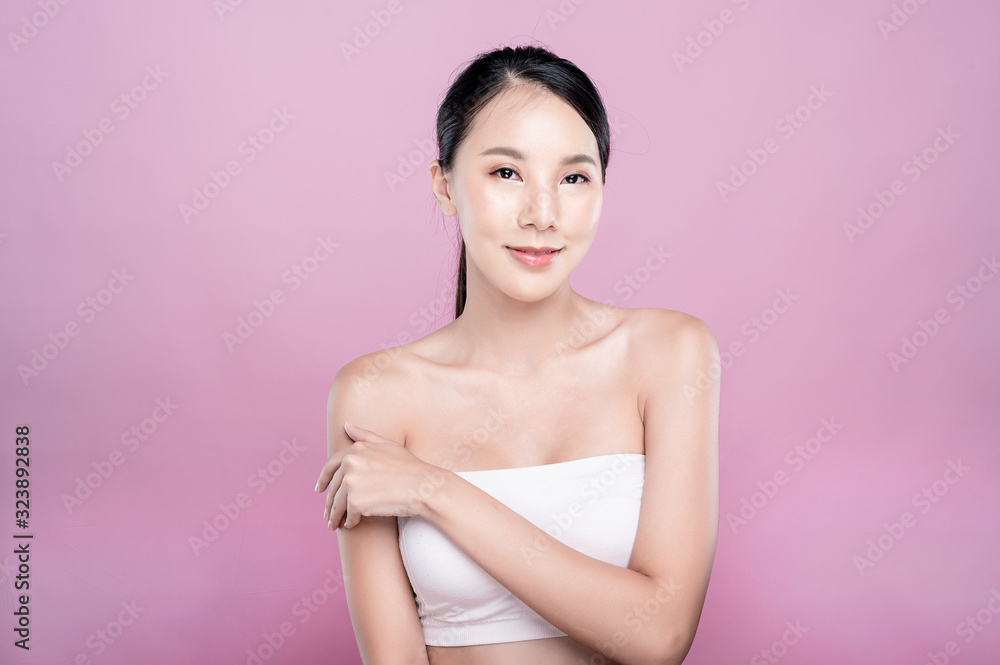 Fototapeta premium Asian woman poses for healthy skin beauty in pink seamless background. Cosmetic, skincare, surgery concept with copy space.