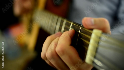male hands playing acoustic guitar