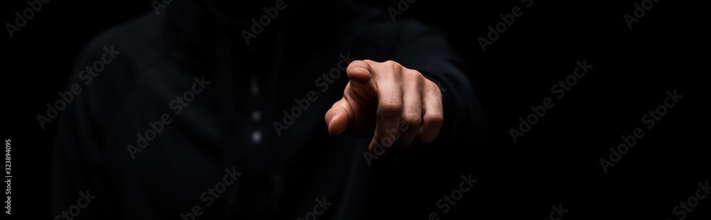 panoramic shot of hacker pointing with finger isolated on black