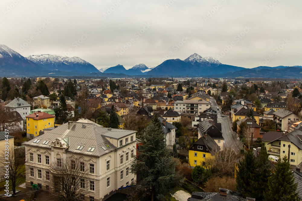 Obraz premium moody depression atmosphere of autumn season in Austrian city Salzburg top view with houses and Alps mountains landscape background