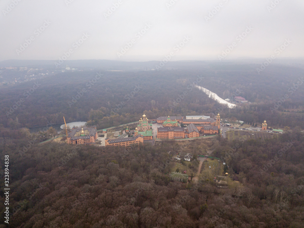 Aerial drone view. St. Pokrovsky Holosiivsky Monastery among coniferous forests