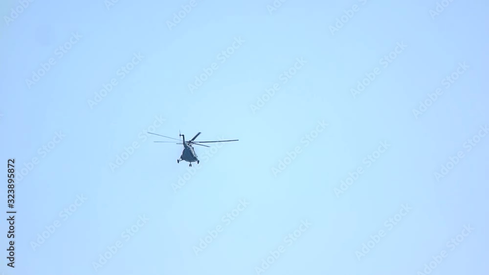 Helicopter flying on a clear blue sky. Back view, slow motion. Helicopter flying on a clear blue sky. Back view, slow motion.