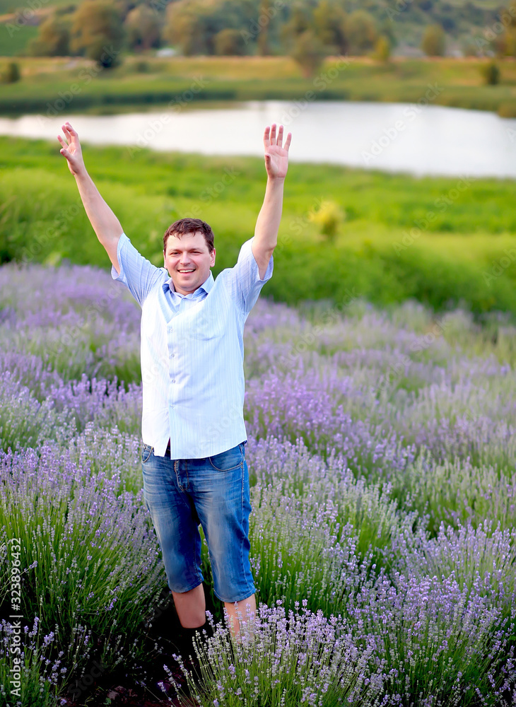 a man in a blue shirt and shorts walks in a lavender field, enjoying the aroma and relaxing on the weekend a man in a blue shirt and shorts walks in a lavender field, enjoying the aroma and relaxing on the weekend