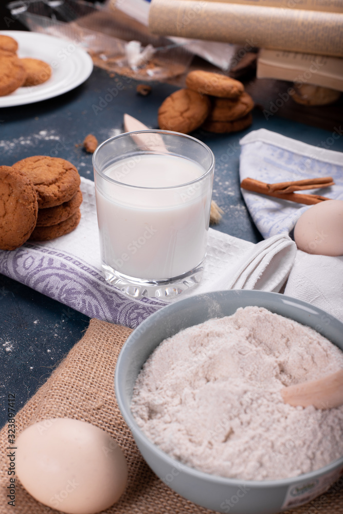 Cup of milk with jar of biscuits and flour Cup of milk with jar of biscuits and flour