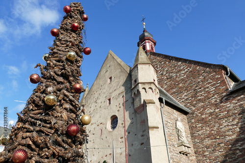 Weihnachtlicher Rebknorzenbaum links mit Kirchenfassade in Rüdesheim am Rhein