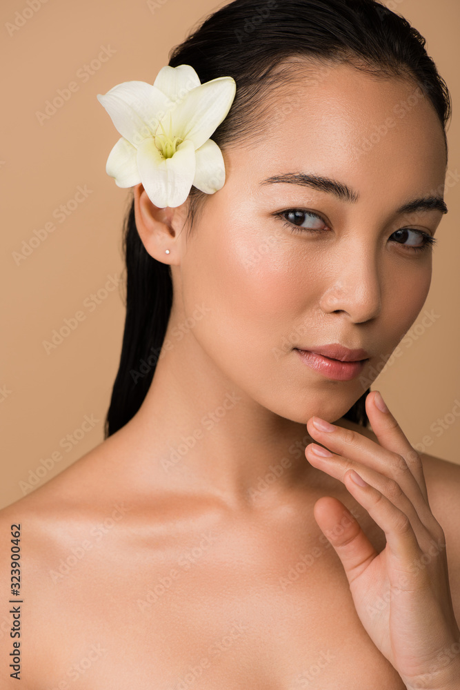 beautiful naked asian girl with white lily in hair isolated on beige beautiful naked asian girl with white lily in hair isolated on beige