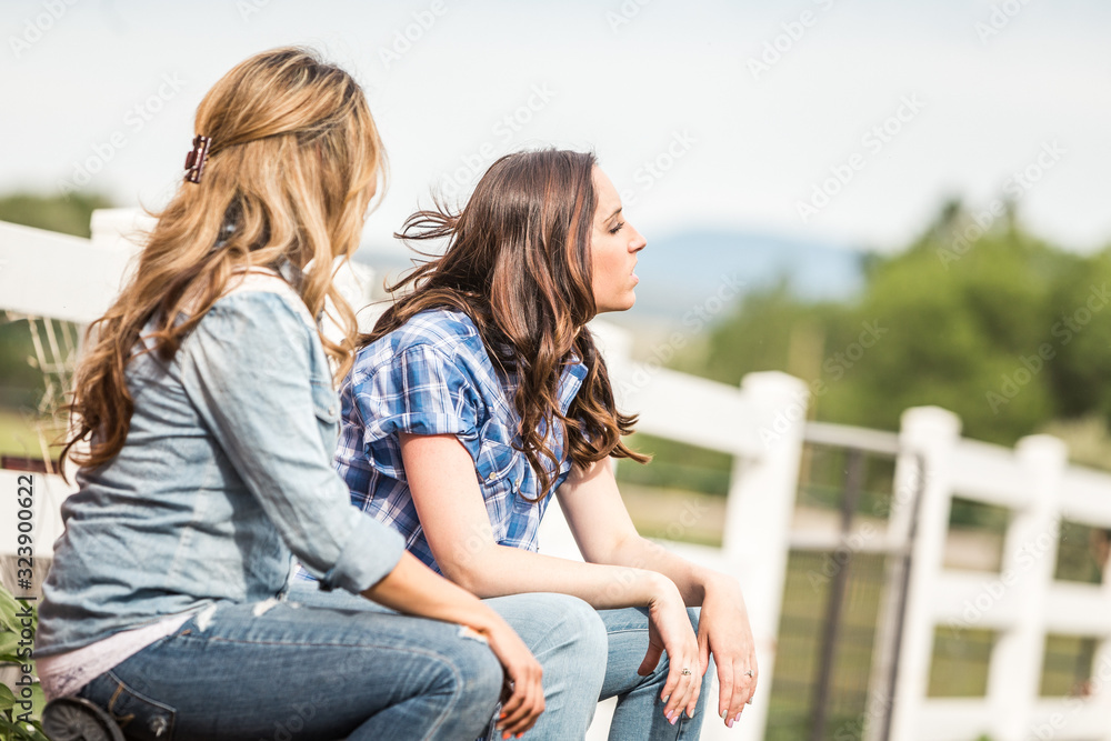 Two western girls hanging out next to stables on a ranch. Bridger, Montana, USA Two western girls hanging out next to stables on a ranch. Bridger, Montana, USA
