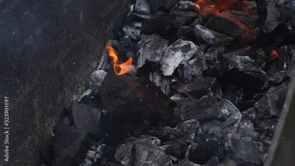 Close up of burning coals in the barbecue grill. Picnic concept. Slow motion Close up of burning coals in the barbecue grill. Picnic concept. Slow motion