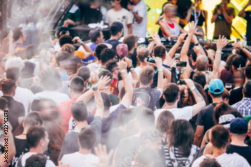 Blurred crowd at music festival. Defocused image.