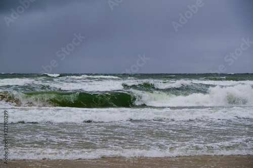 Rough sea with waves during autumn stormy weather. Black heavy clouds in the sky. Baltic Sea, Dziwnowek, Poland