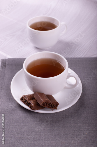 Cup of tea and chocolate with light background