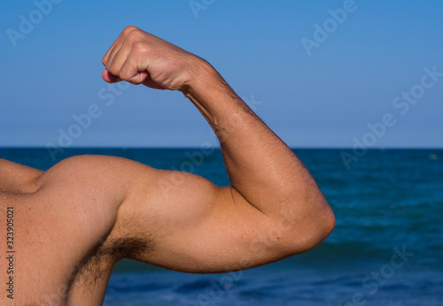 Portrait of a strong healthy handsome athletic man model fitness isolated on sea background