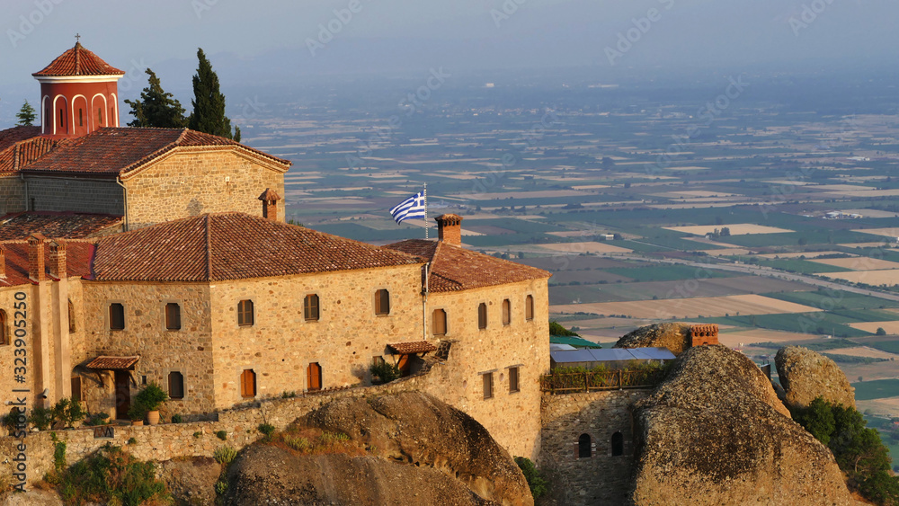 Greek flag on Meteora Monastery above valley, Greece Greek flag on Meteora Monastery above valley, Greece