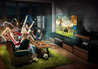 Group of friends watching TV, match, championship, sport games. Emotional men and women cheering for favourite female soccer team, emotions. Concept of friendship, sport, competition, emotions.