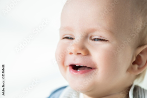 Portrait of laughing baby boy looking away isolated on white
