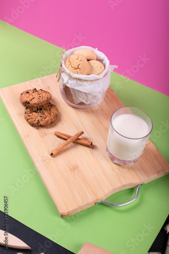 Cup of milk with cinnamon biscuits on tablecloth