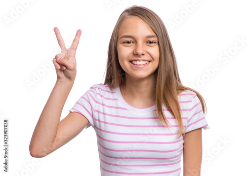 Portrait of successful teen girl winner making Victory Gesture, isolated on white background. Beautiful caucasian young teenager. Happy cute child showing success sign and looking at camera.