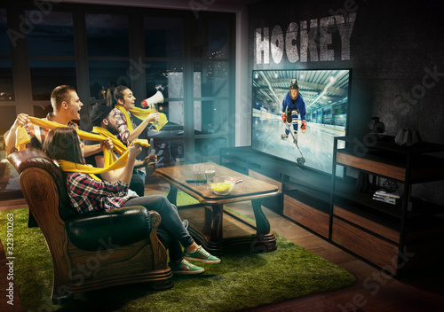 Group of friends watching TV, hockey match, championship, sport games. Emotional men and women cheering for favourite hockey team of teens. Concept of friendship, sport, competition, emotions.