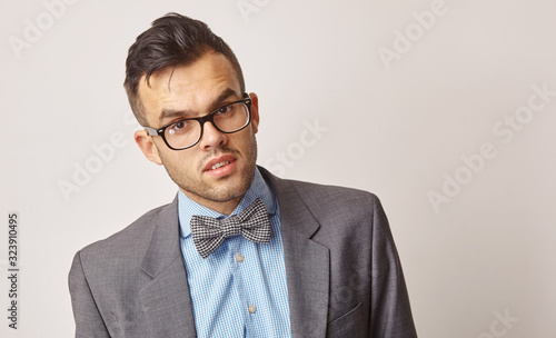 portrait of a young man in a blue shirt with a butterfly and glasses