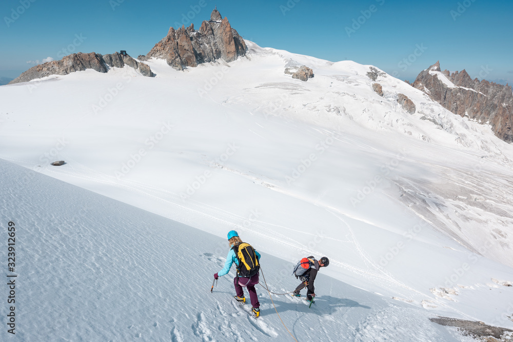 Mountaineering team descending down a snowy mountain face in the Mont Blanc Massif