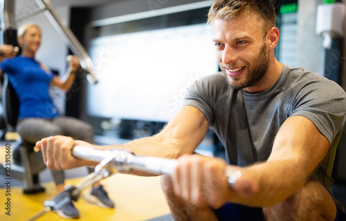 Young handsome man doing exercises in gym