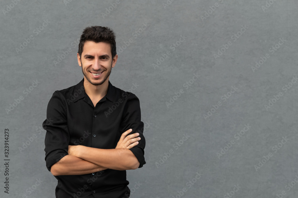 A young handsome man is standing in a black business suit on the background of an office building. The concept of a successful, confident young businessman. A young handsome man is standing in a black business suit on the background of an office building. The concept of a successful, confident young businessman.