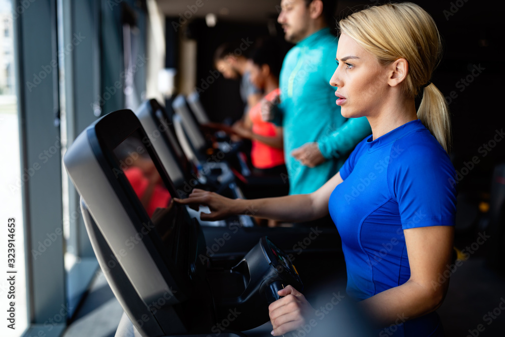 Fototapeta premium Young attractive woman doing cardio training in gym