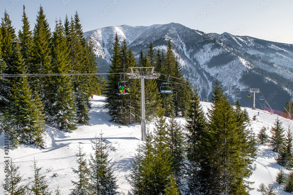 Ski lift chair with skiers in resort Chopok Juh at Low Tatras mountains, Slovakia