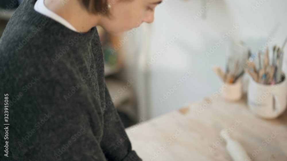 Potterry woman making clay blank for the ceramics work. Handheld shot from face till hands. Working on the table. Slowmotion. Potterry woman making clay blank for the ceramics work. Handheld shot from face till hands. Working on the table. Slowmotion.