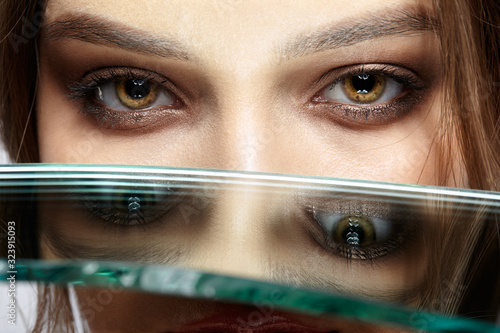 Portrait of a beautiful girl with a mirror splinter near eyes.