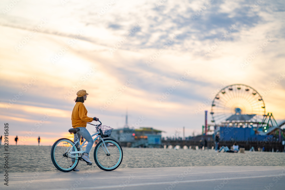 Young woman with bike on the beach in Los Angeles