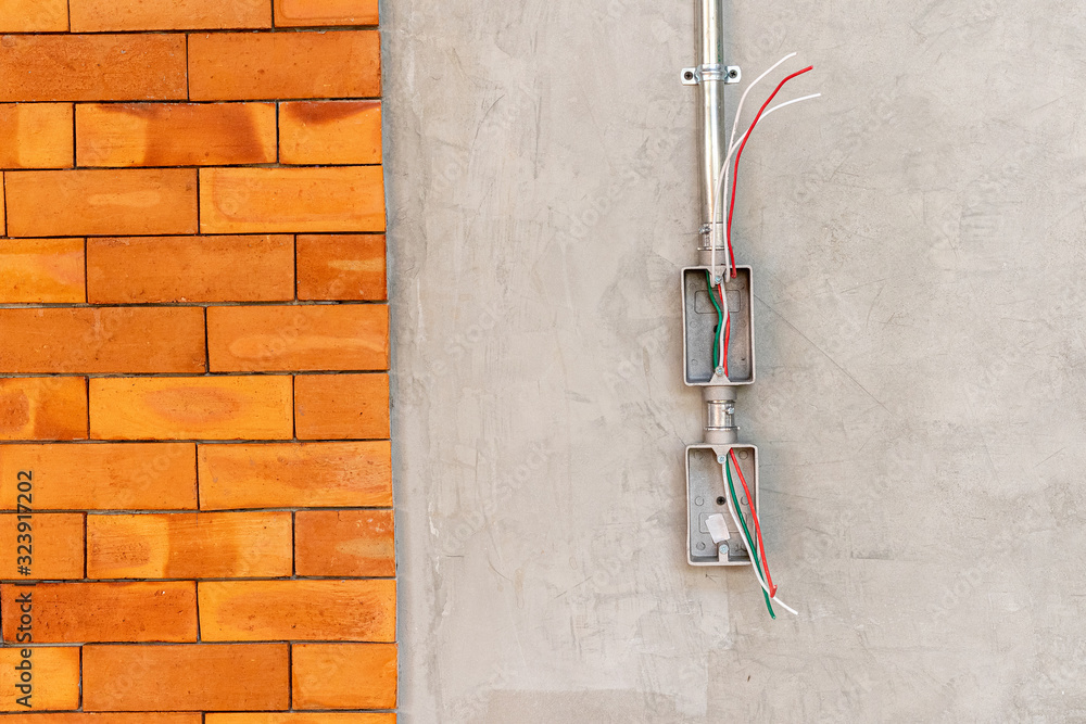 Electrical socket boxes with wires on cement wall in a wall under construction unfinished frame, Unfinished electrical plug box on the cement wall - Interior concept. Electrical socket boxes with wires on cement wall in a wall under construction unfinished frame, Unfinished electrical plug box on the cement wall - Interior concept.