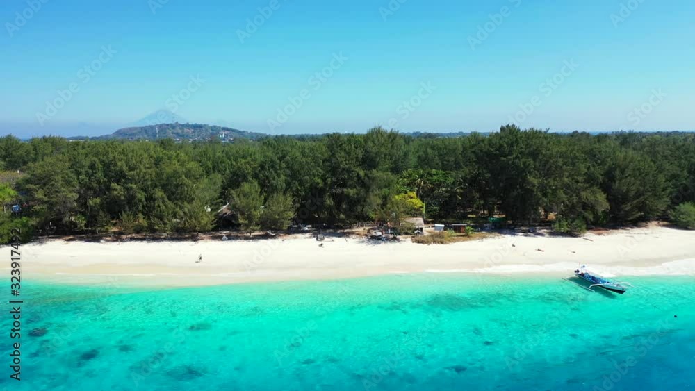 Beautiful empty white sand beach with turquoise water and small fishing boats near the coast in Indonesia Beautiful empty white sand beach with turquoise water and small fishing boats near the coast in Indonesia