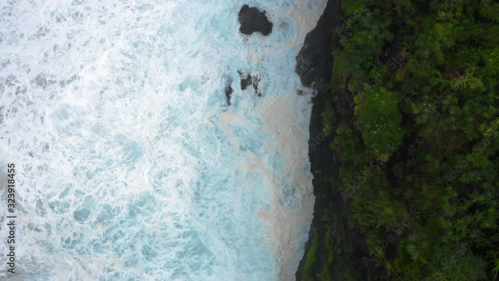 Beautiful ocean surf washes steep coastal cliffs covered with dense tropical greenery. Water is blue and clear, it boils at the feet of the rocks. Aerial footage, view from above. 4K Beautiful ocean surf washes steep coastal cliffs covered with dense tropical greenery. Water is blue and clear, it boils at the feet of the rocks. Aerial footage, view from above. 4K