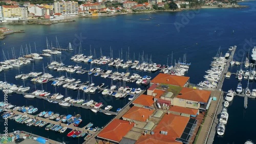 Aerial, pan, drone shot of a harbor full of boats, on a sunny day, in Pontevedra, Galicia, North Spain photo