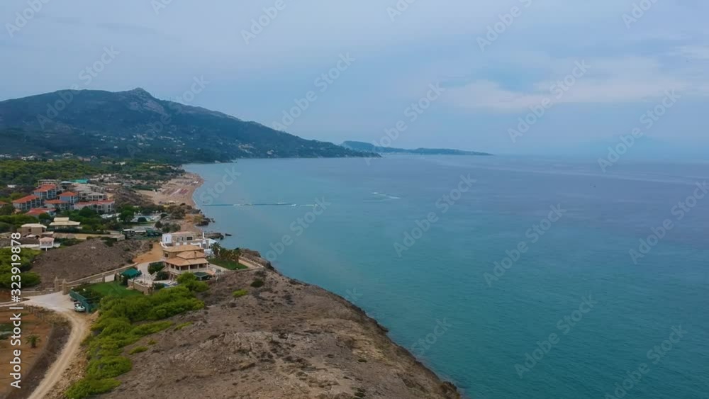 Zakynthos Greece island's Point St. Nicholas cliffs with beautiful beach homes, Aerial drone flyover shot looking northward Zakynthos Greece island's Point St. Nicholas cliffs with beautiful beach homes, Aerial drone flyover shot looking northward